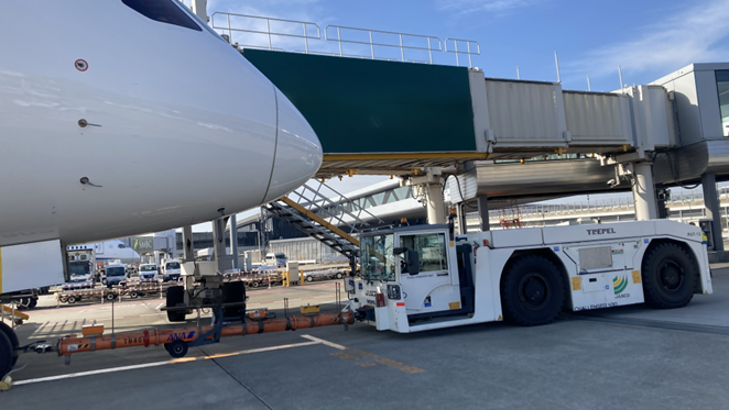 プッシュバックトラクターが、飛行機を後退させている。出発を支える「プッシュバック」の瞬間