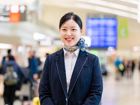 空港ロビーで立っている女性のグランドスタッフ