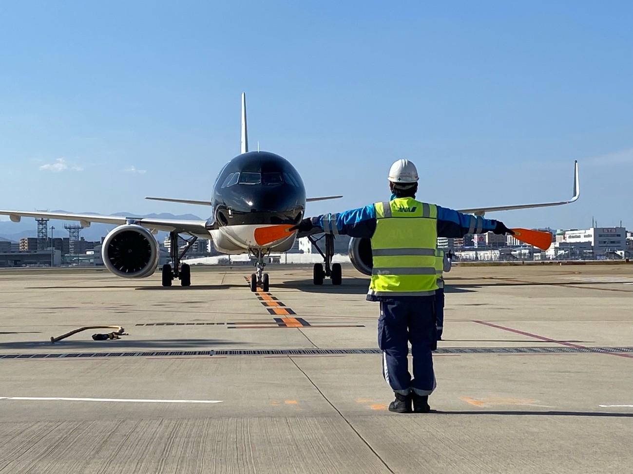 航空機を誘導するKAPS福岡事業部グランドサービス課の廣重和哉